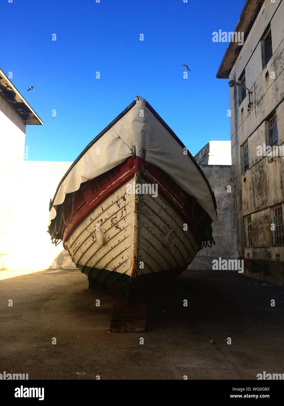 Boat By Building Against Clear Sky Stock Photo