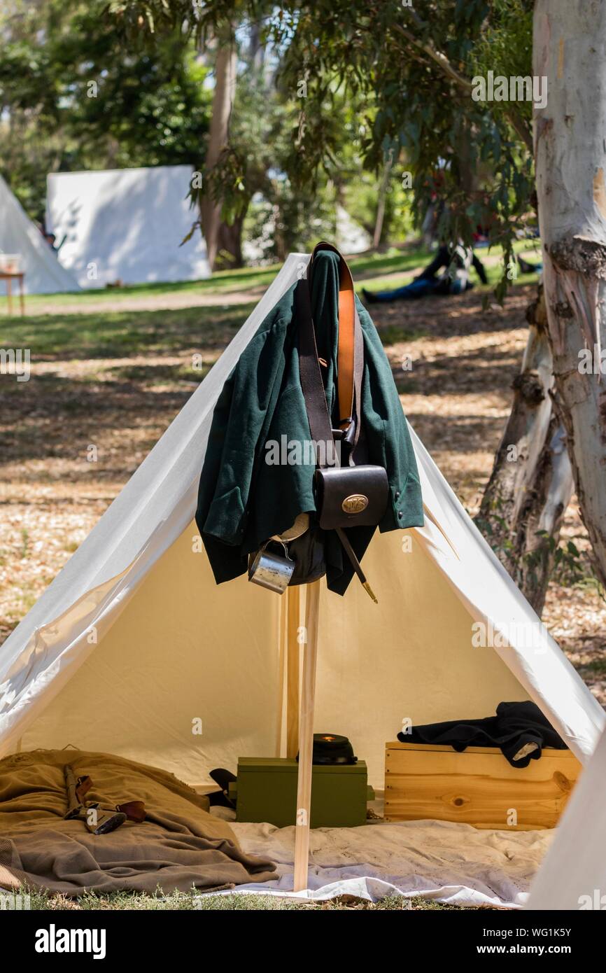 A Civil War era jacket and accessories hang on a white canvas tent during an American Civil War reenactment Stock Photo