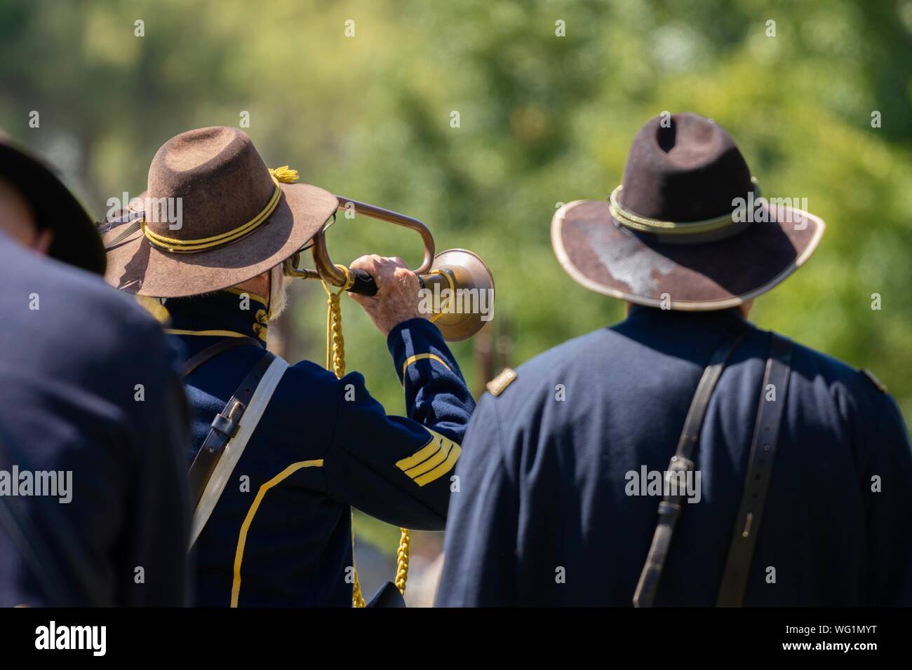 A man plays the trumpet at the end of a battle during an American Civil War reenactment Stock Photo