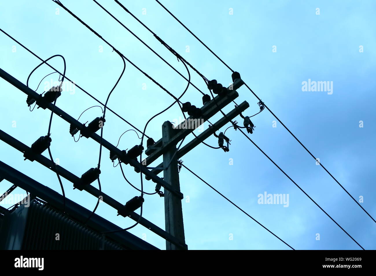 High voltage power lines installing on high electric post connected to many electrical equipments. Photo taken just after raining Stock Photo