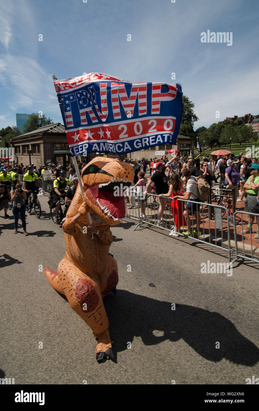 Boston, MA, USA.  31st August 2019.  Hundreds march in the Straight Pride Parade through Boston, MA.  The marchers, supporters of U.S. President Donald Trump, were outnumbered by anti-Trump and gay rights supporters. The Straight Pride march was organized by the newly formed “Super Happy Fun America”, who organized the Boston event as a response to gay pride parades that have been held in most major U.S, cities. Photo shows a man dressed as a dinosaur carrying a Trump 2020 on Boylston Street at the start of the parade. Credit Chuck Nacke / Alamy Live News Stock Photo