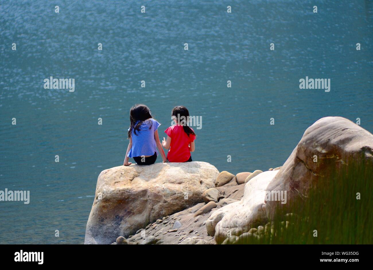 Girls sitting on rock hi-res stock photography and images - Alamy