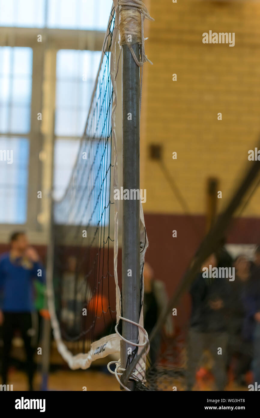 Raggedy volleyball net on a grey metal pole during a school sport event Stock Photo