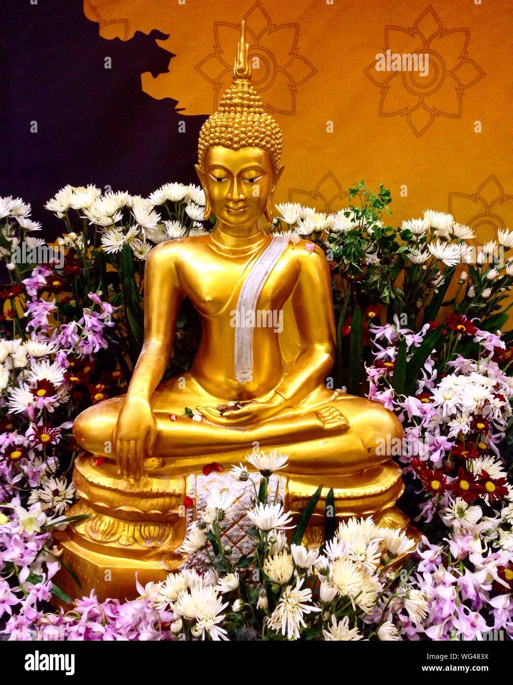 Golden Buddha Statue Amid Flowers Stock Photo
