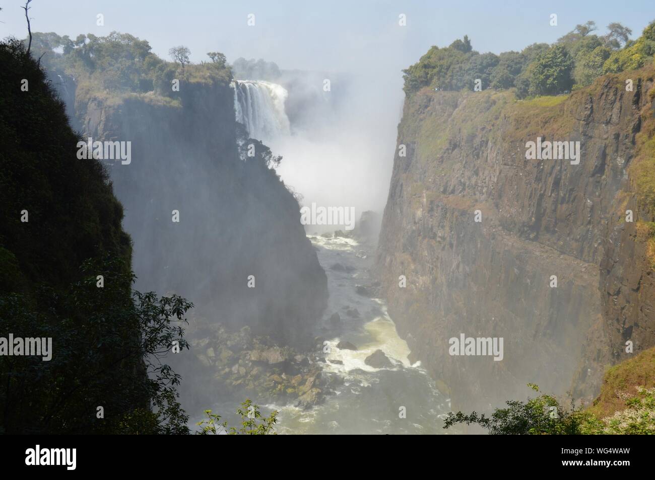Scenic View Of Victoria Falls Amidst Mountain Valley Stock Photo