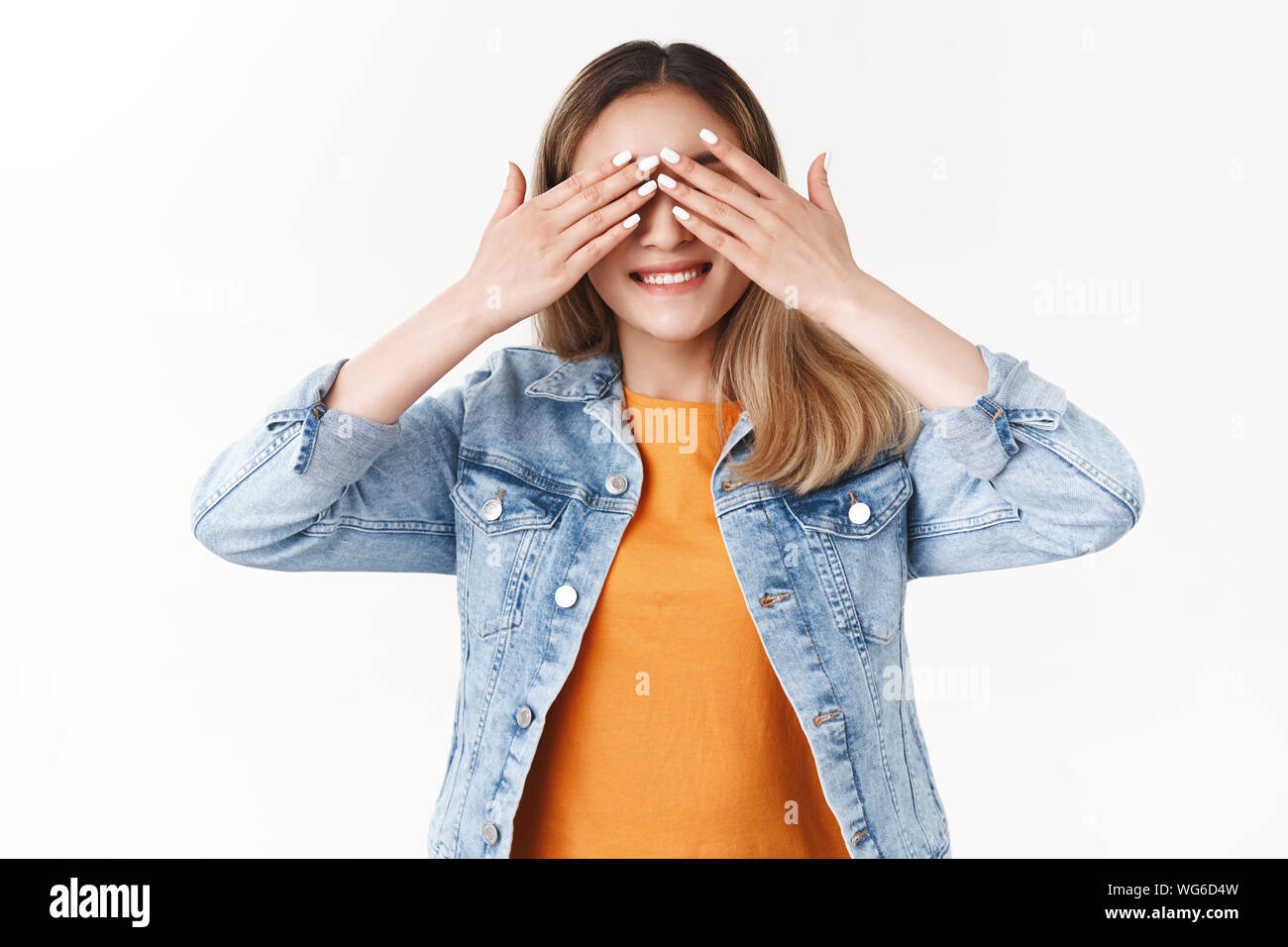 Can i open eyes now. Cheerful enthusiastic cute asian blond girl cover sight smiling anticipating eager see what gift surprise prepared friends b-day Stock Photo