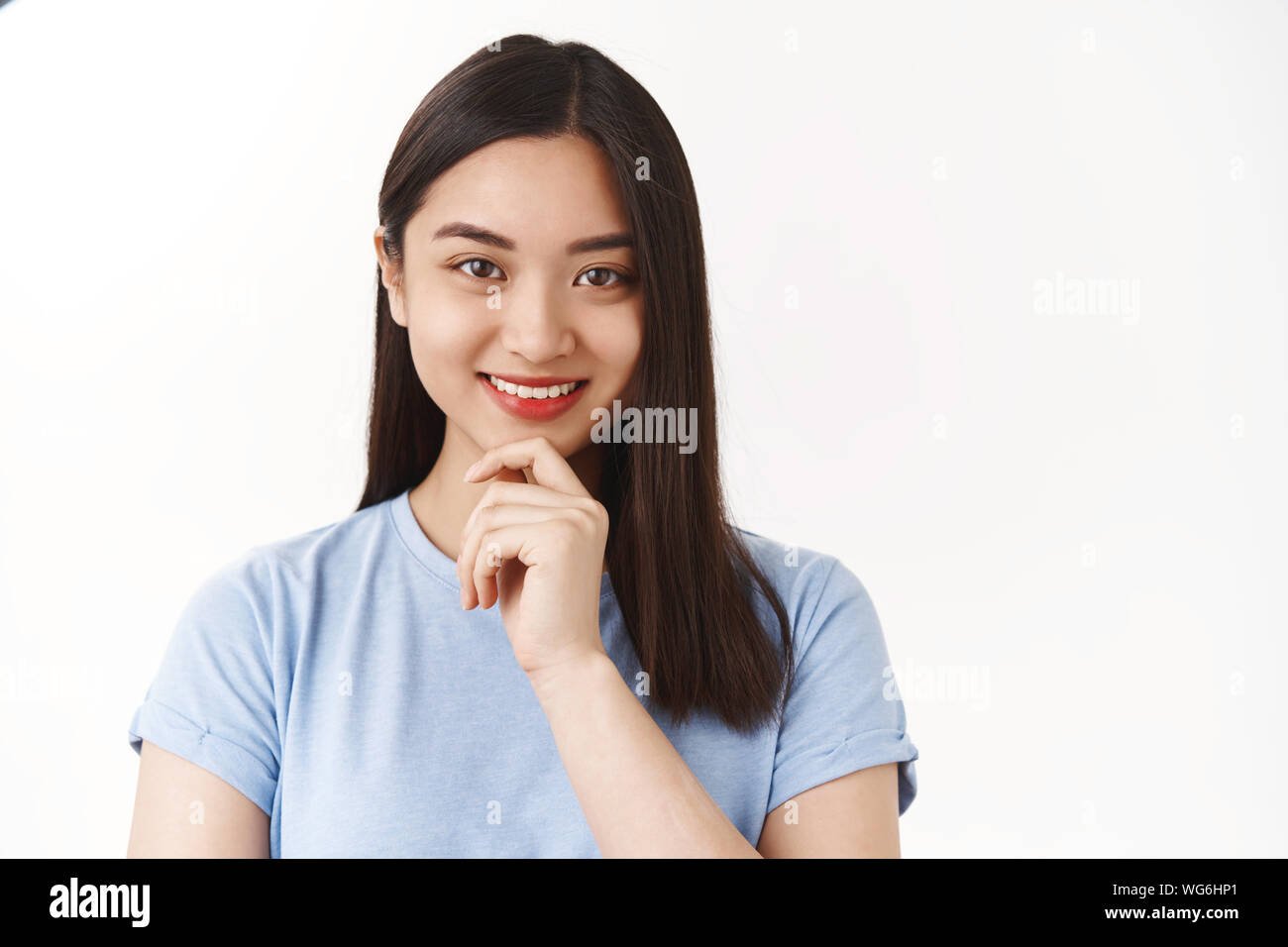 How interesting. Cute creative asian female freelancer ponder ideas choices smiling delighted touch chin thinking making decision standing white Stock Photo