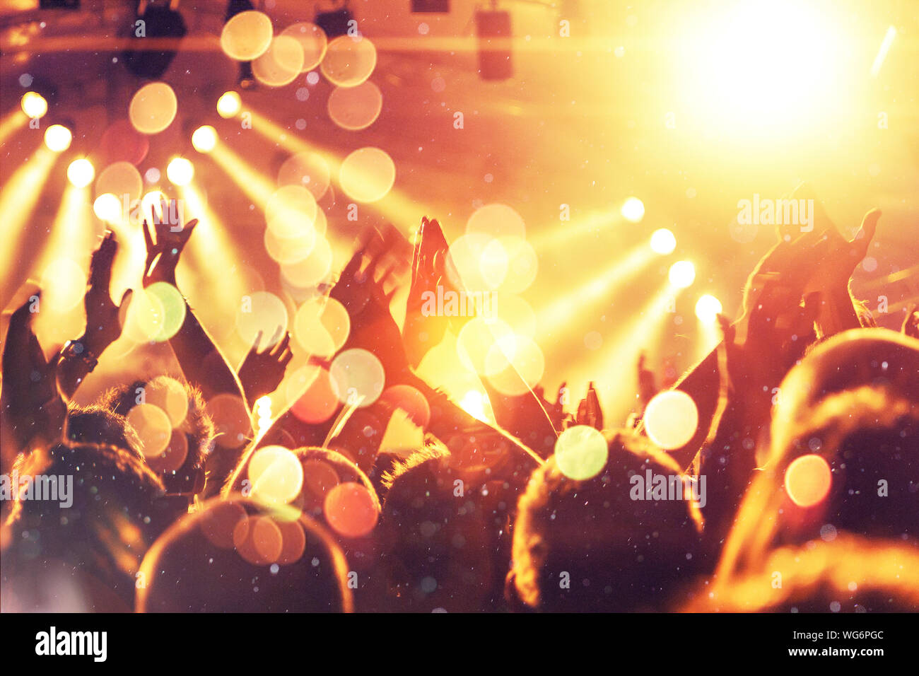 Concert crowd clapping in front of a bright stage Stock Photo Alamy