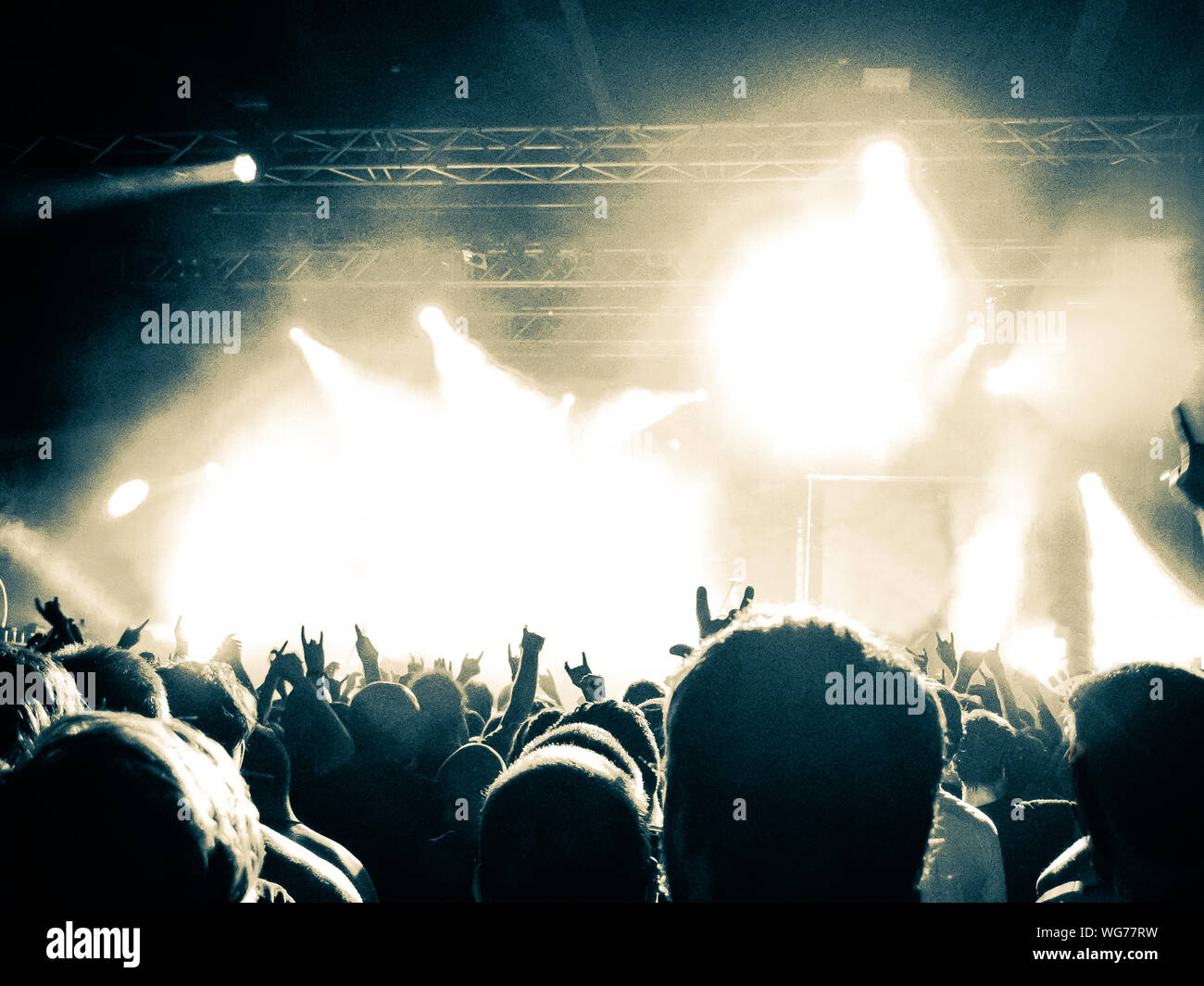 Concert crowd clapping in front of a bright stage Stock Photo Alamy