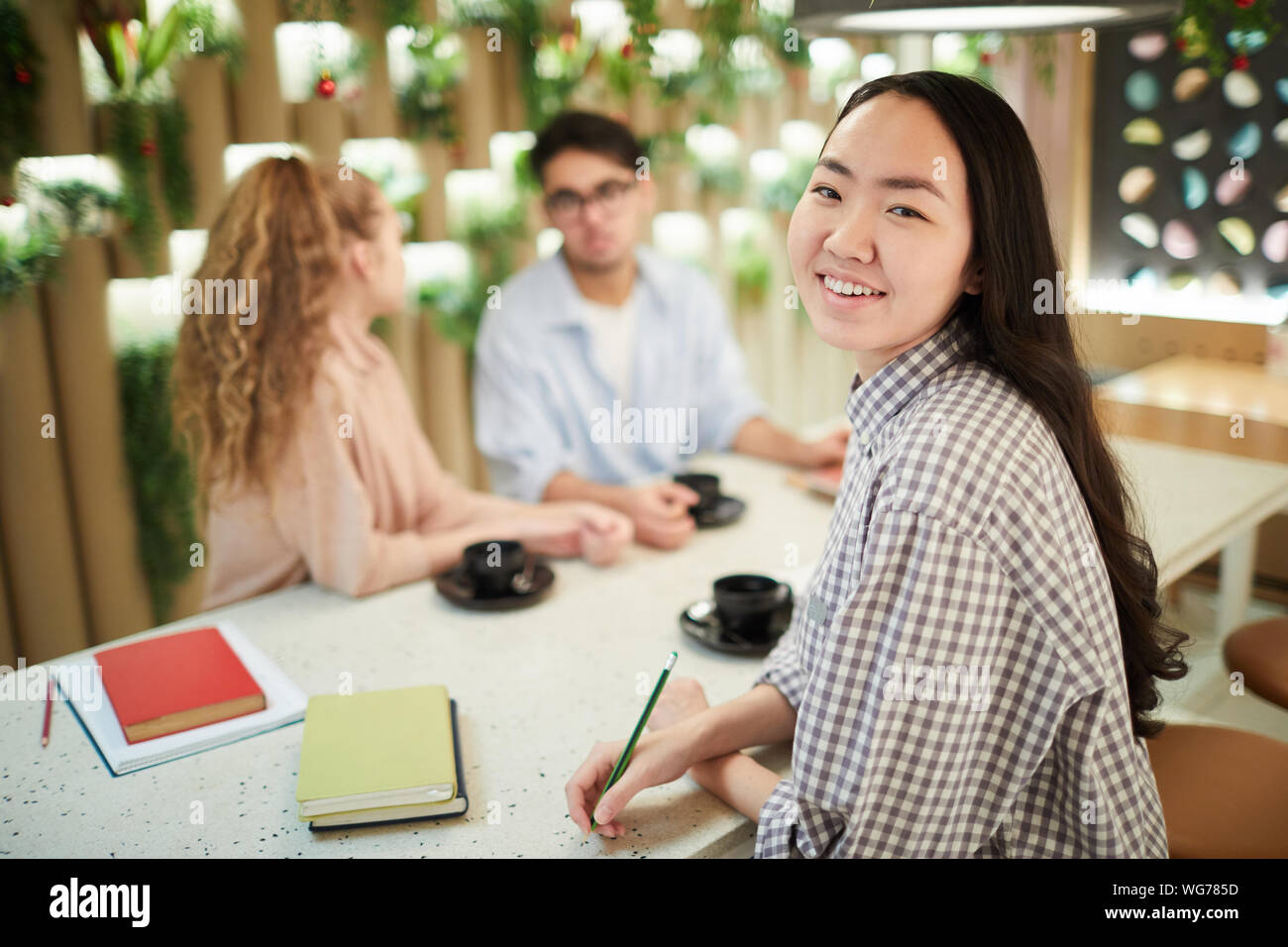 Multi-ethnic group of students studying together in cafe, focus on ...