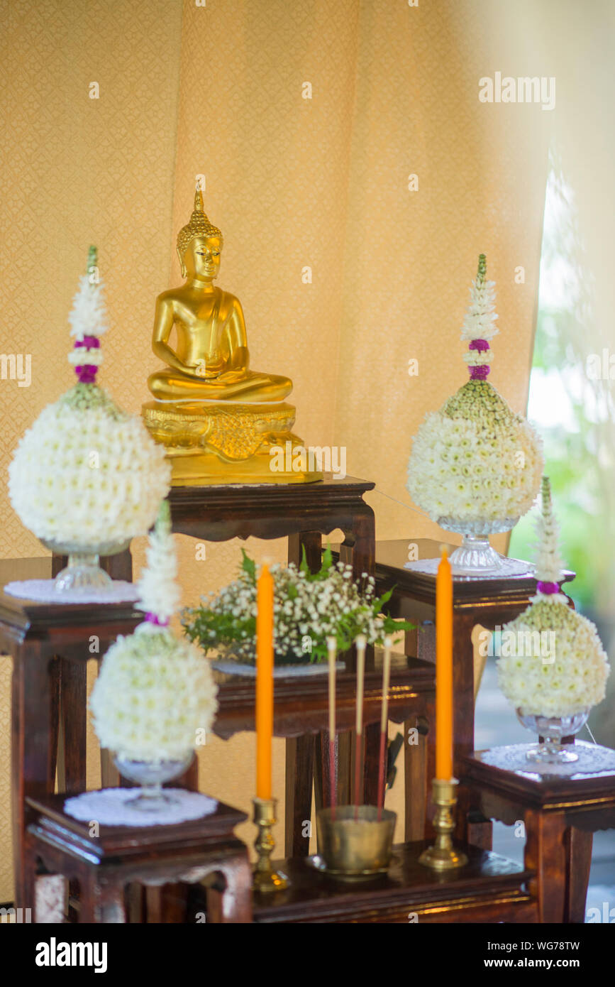 Golden Buddha Statue And White Flowers On Wooden Furniture During