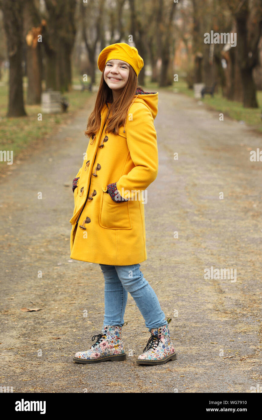 beautiful teenage girl in a yellow coat and beret autumn season Stock ...