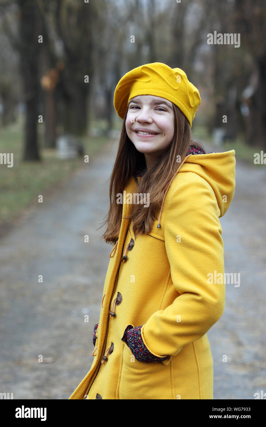 beautiful teenage girl in a yellow coat and beret portrait autumn