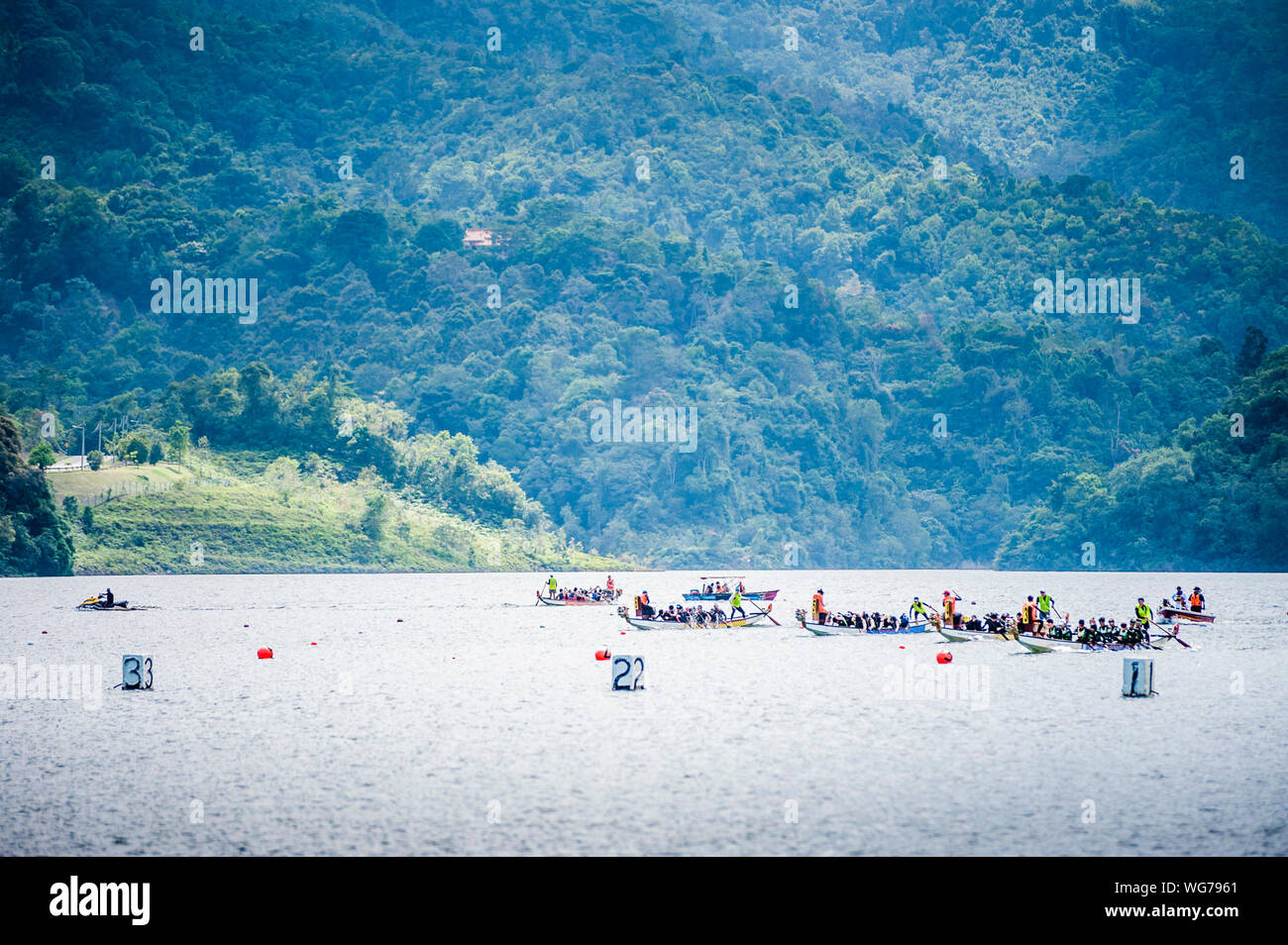 Dragon Boat Race In River Against Mountain Stock Photo