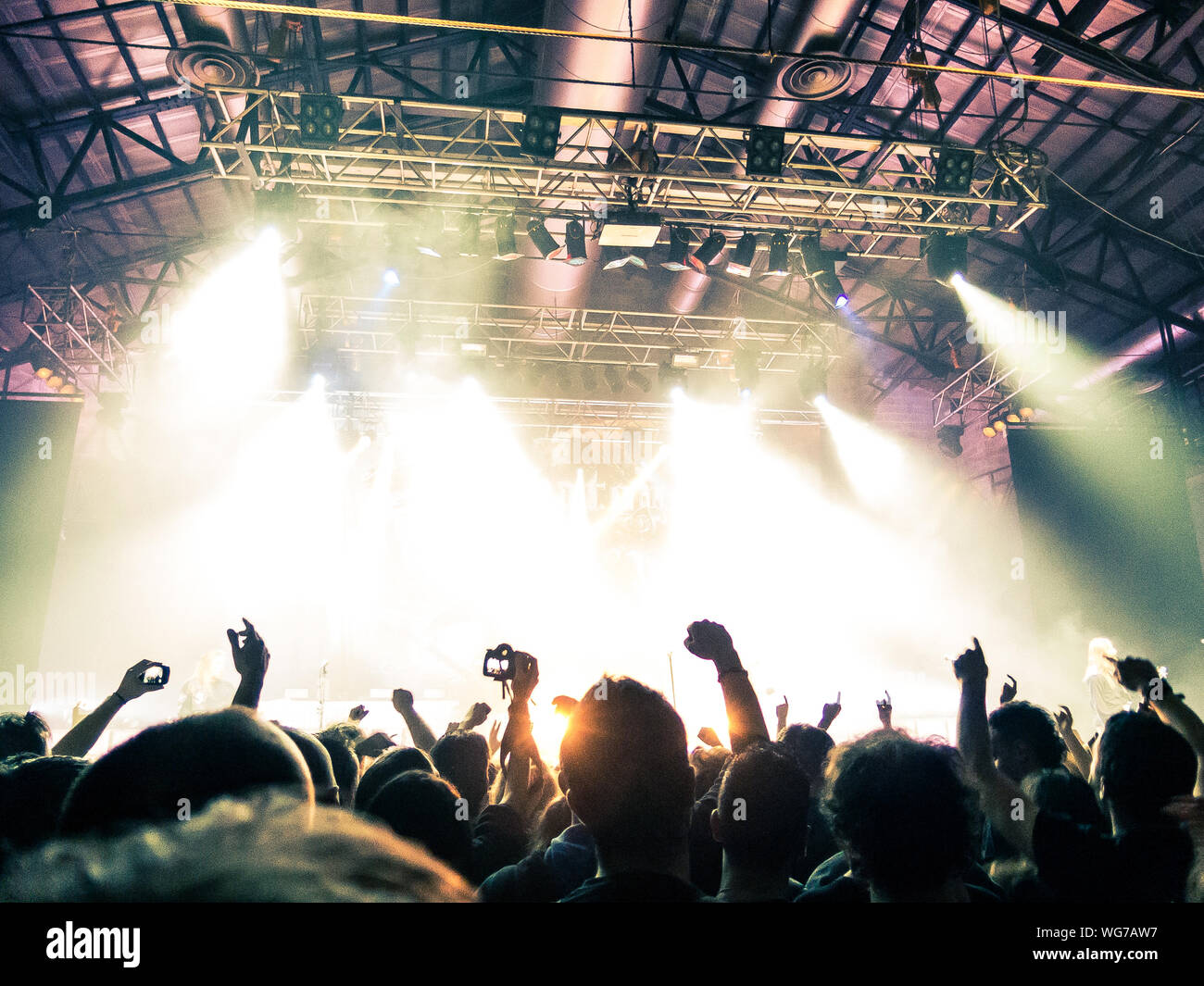 Concert crowd clapping in front of a bright stage Stock Photo Alamy