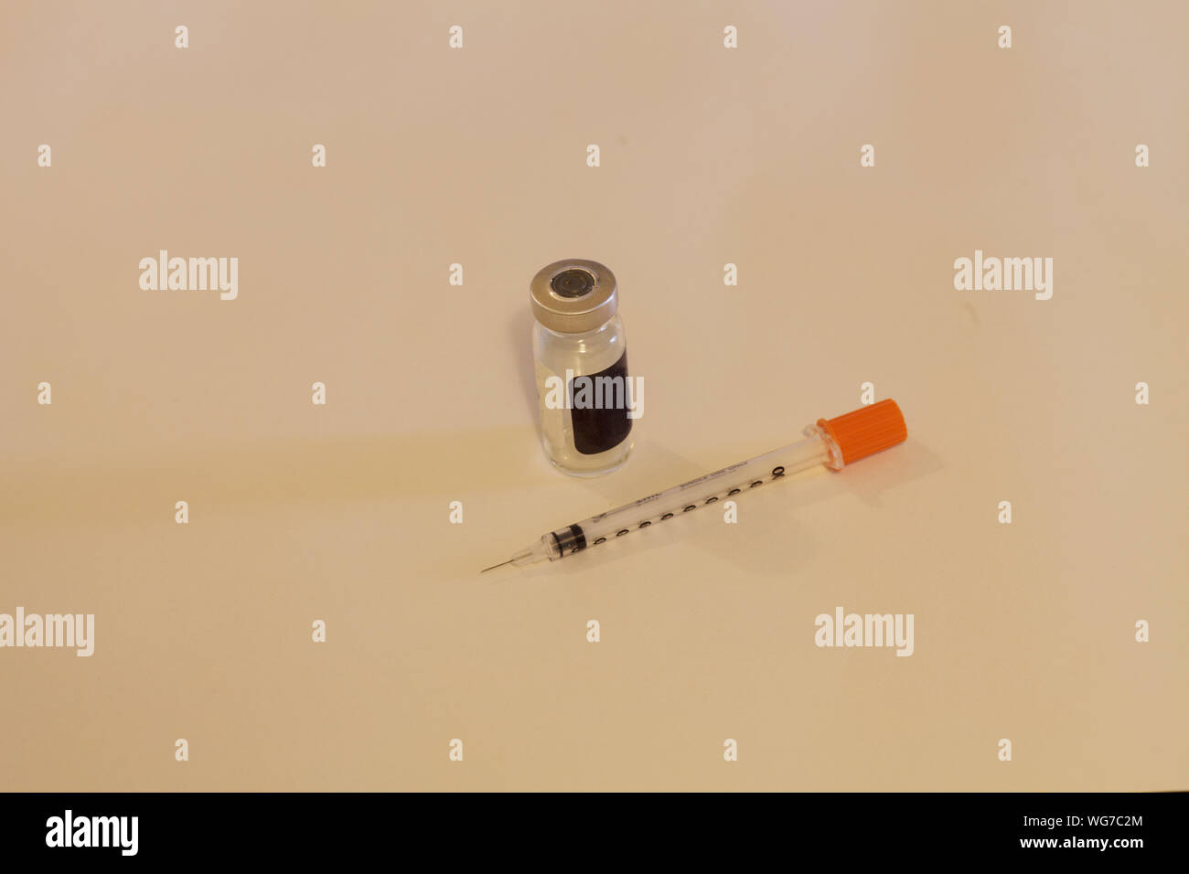 High Angle View Of Syringe And Medicine Bottle On Beige Background Stock Photo