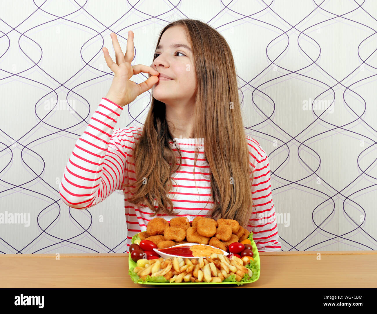 teenage girl with chicken nuggets and ok hand sign Stock Photo