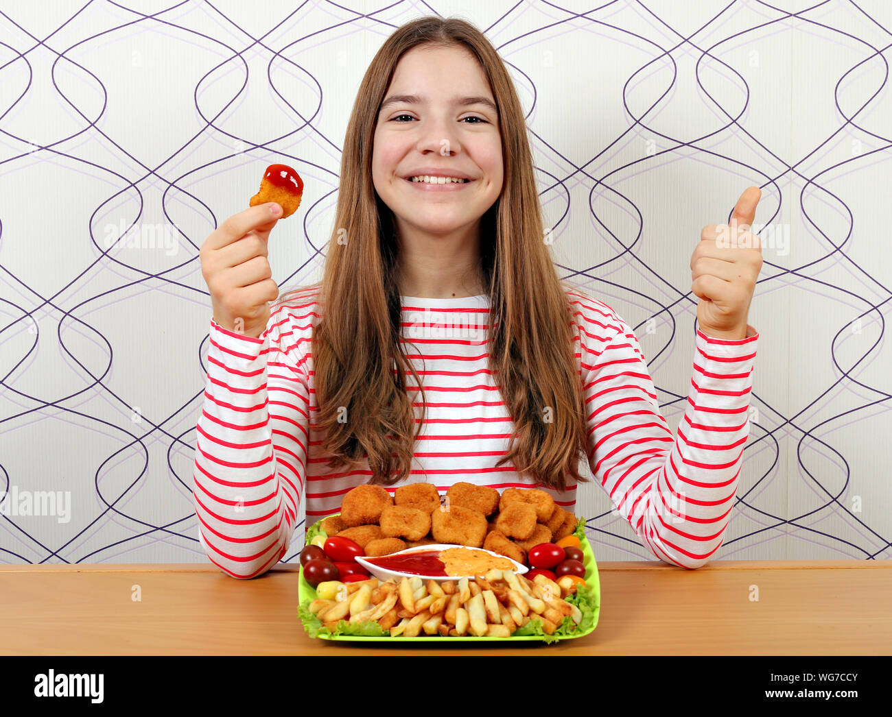 teenage girl with tasty chicken nuggets and thumbs up Stock Photo
