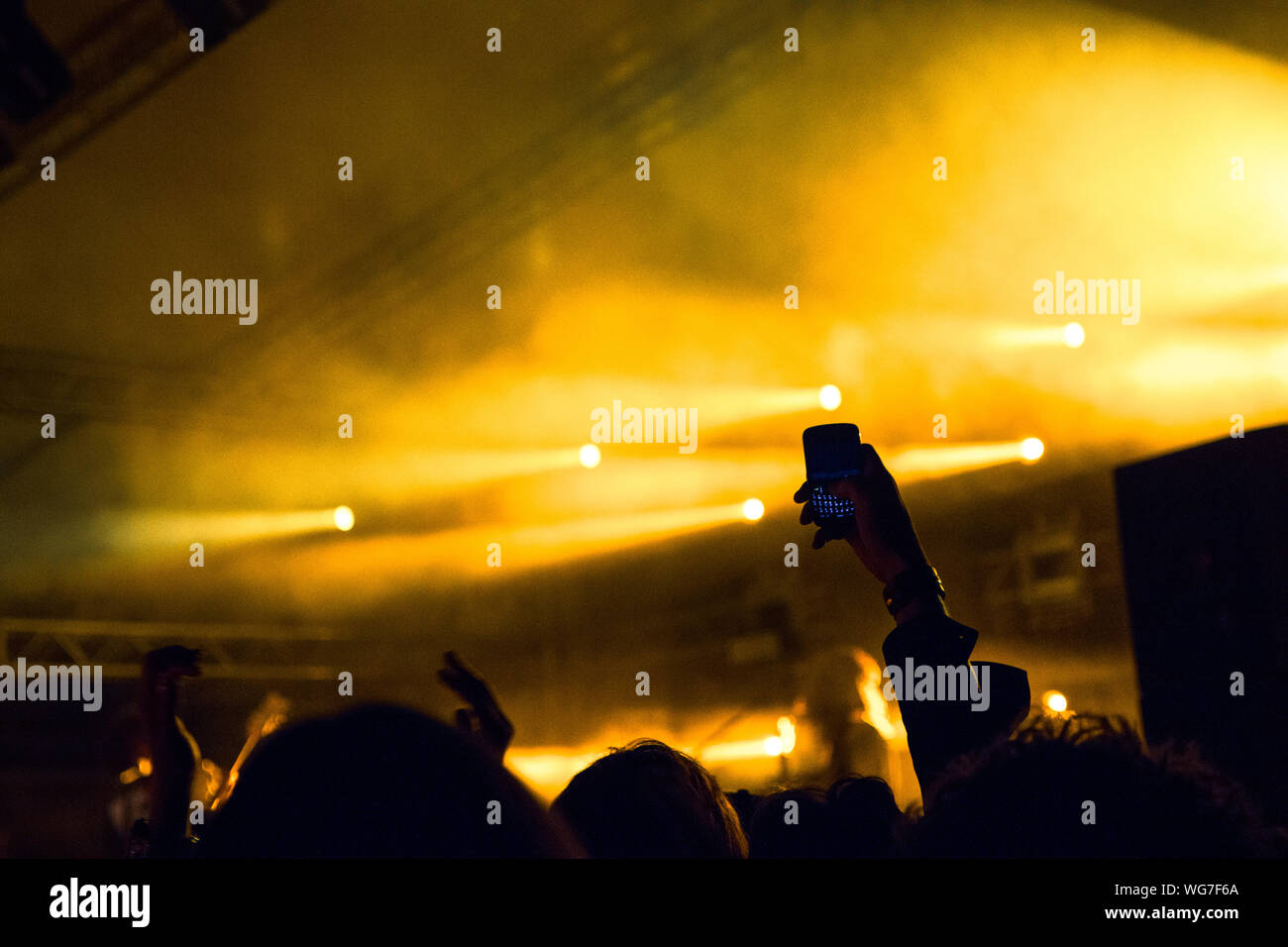 Concert crowd clapping in front of a bright stage Stock Photo Alamy