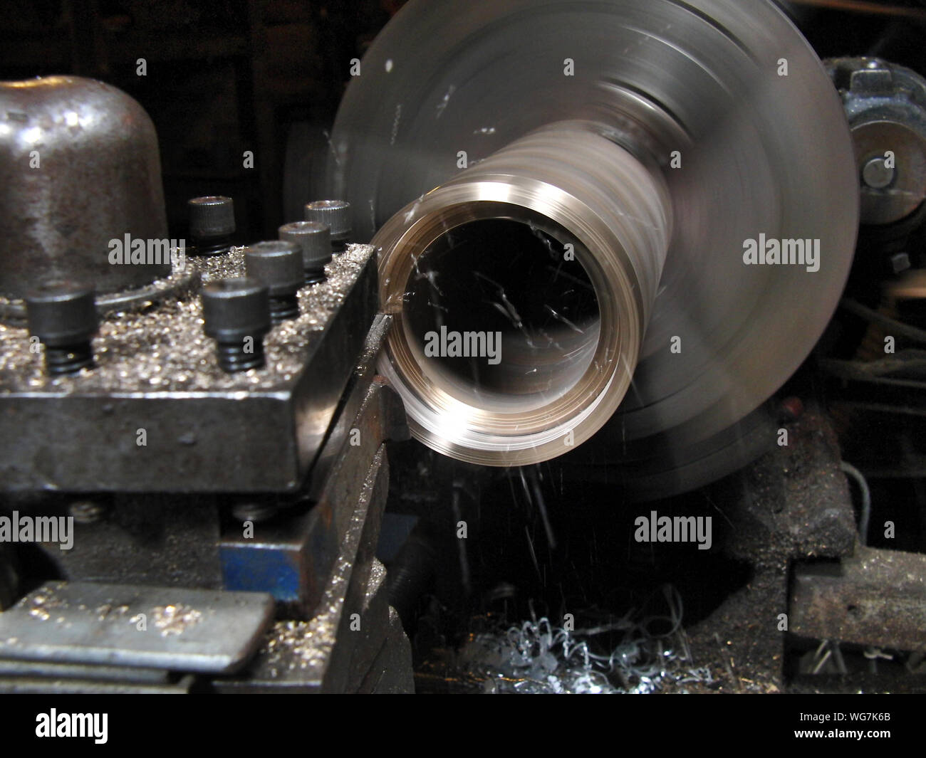 Bronze tube being processeed in an old lathe Stock Photo