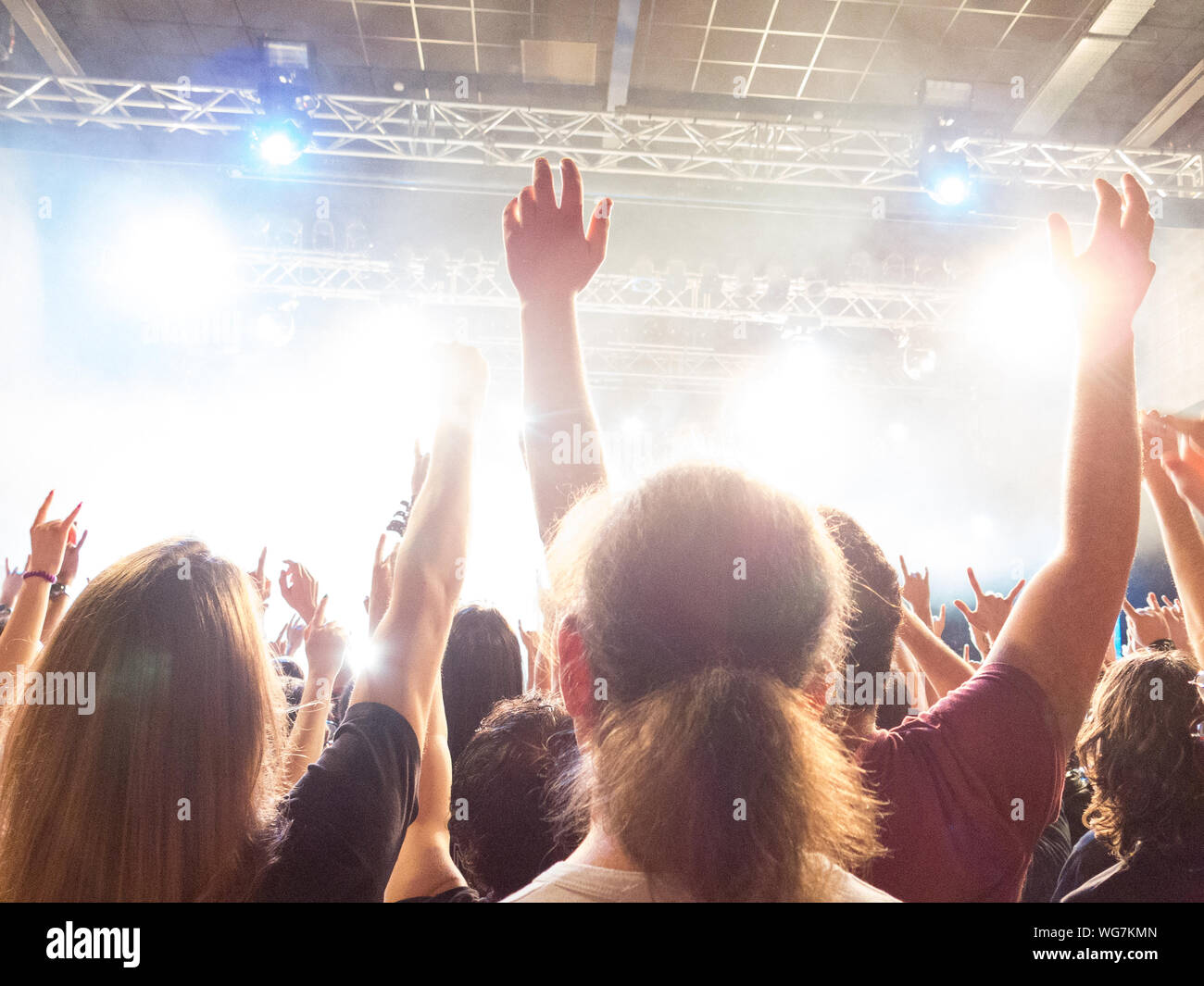 Concert crowd clapping in front of a bright stage Stock Photo Alamy