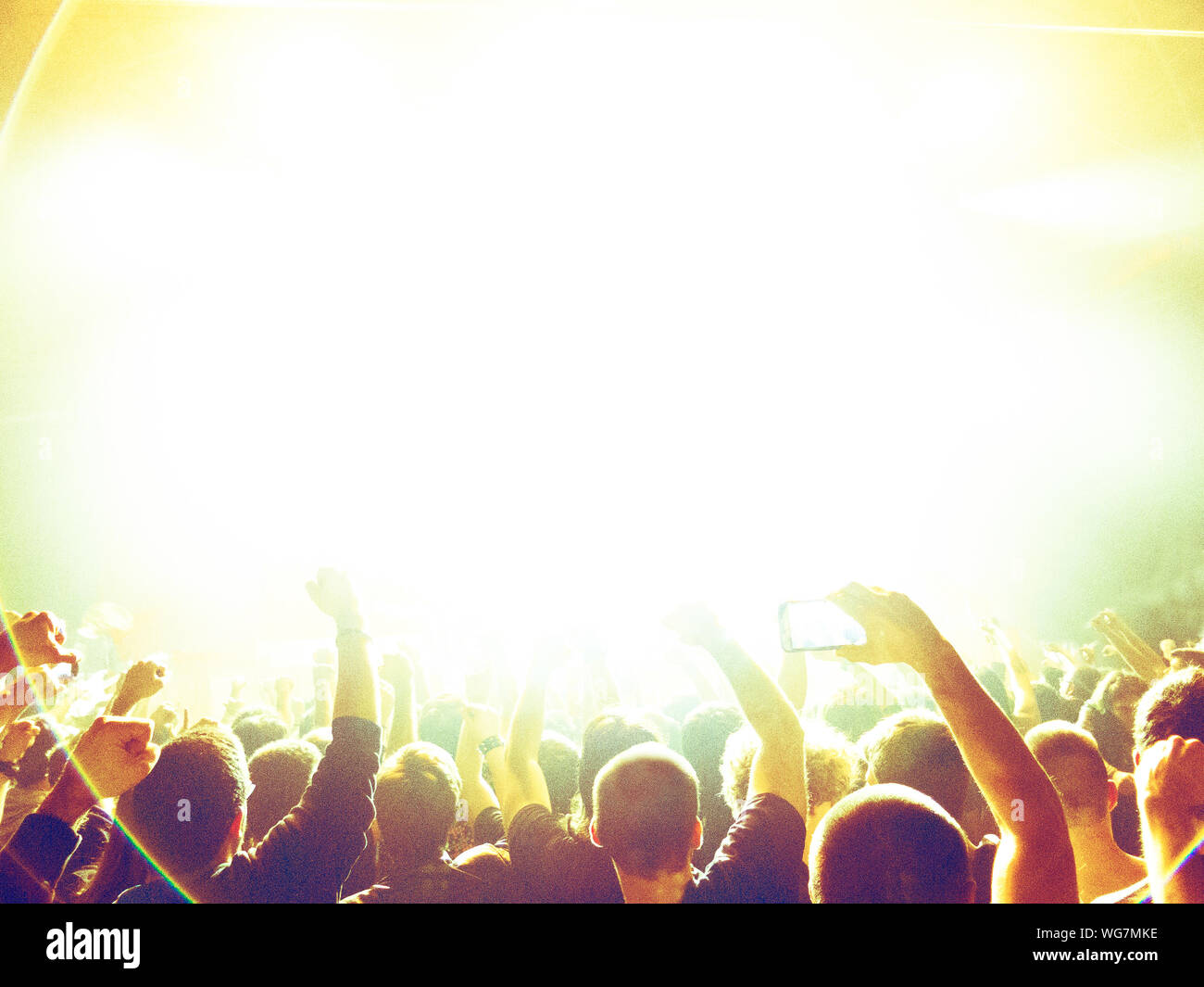 Concert crowd clapping in front of a bright stage Stock Photo Alamy