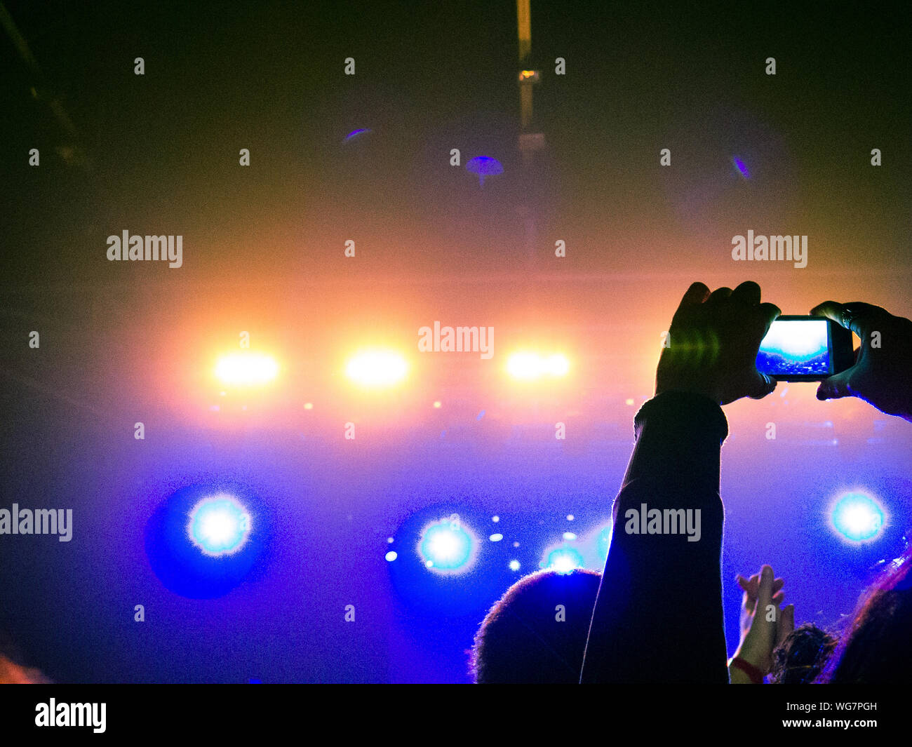 Concert crowd clapping in front of a bright stage Stock Photo Alamy