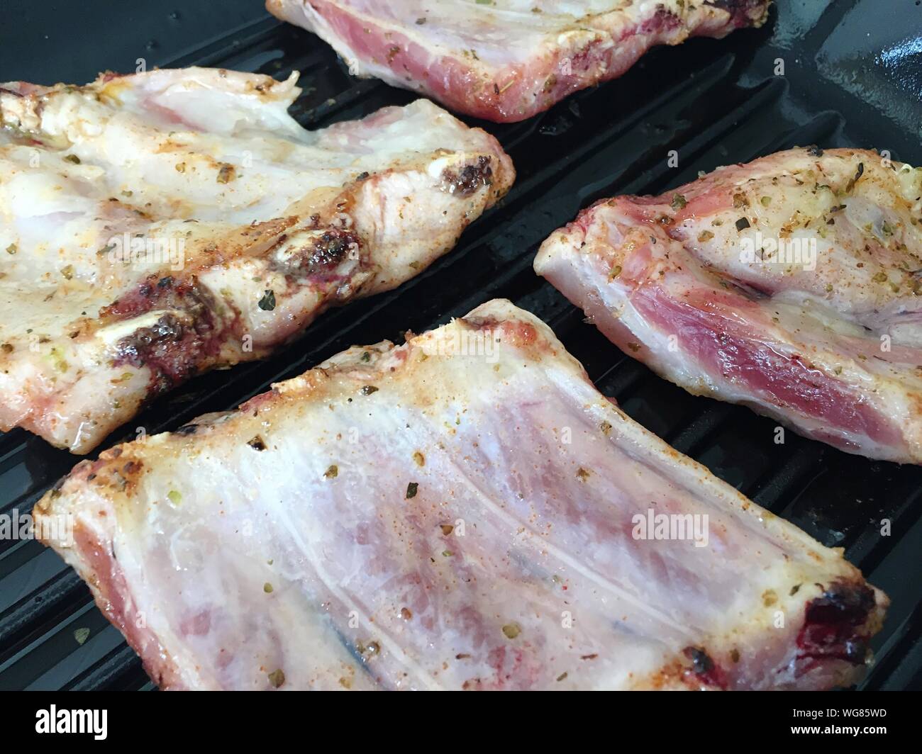 High Angle View Of Ribs Being Roasted In Griddle Pan Stock Photo