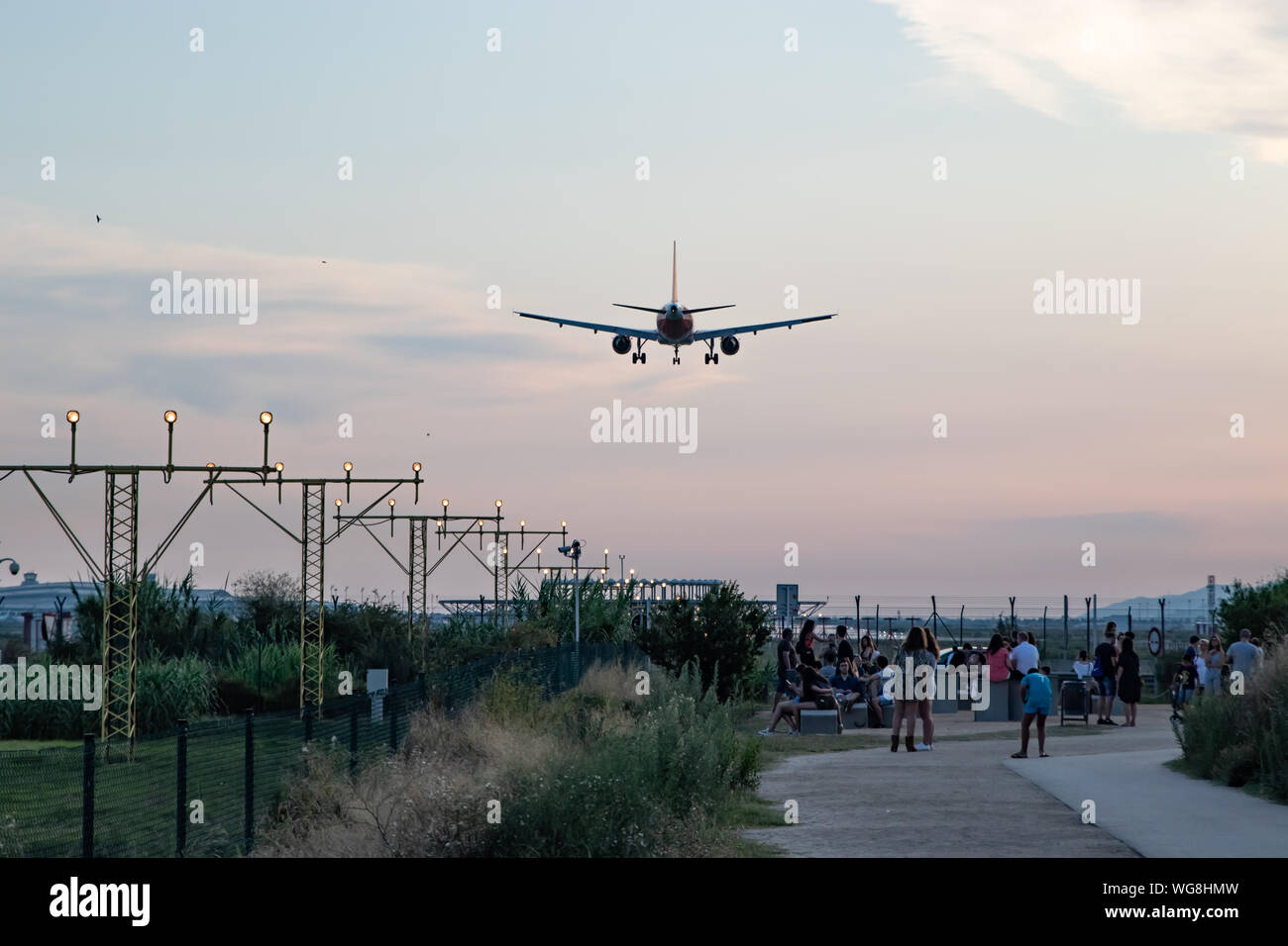 Aircraft landing in El Prat Barcelona airport overflying a group of people Stock Photo