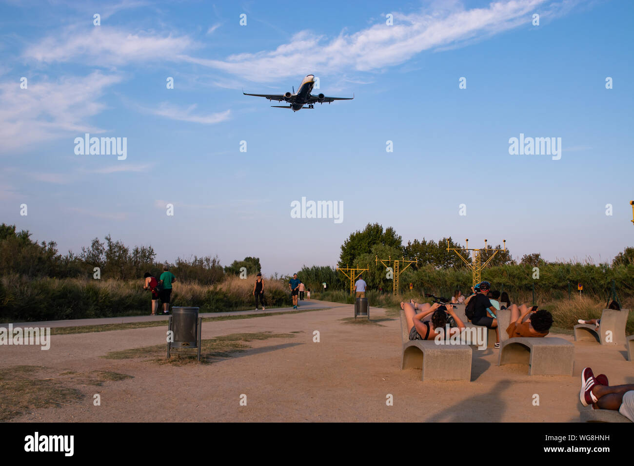 Barcelona, Spain - August 30, 2019: People watching and taking pictures of a landing aircraft from the runway viewpoint of Barcelona El Prat airport Stock Photo