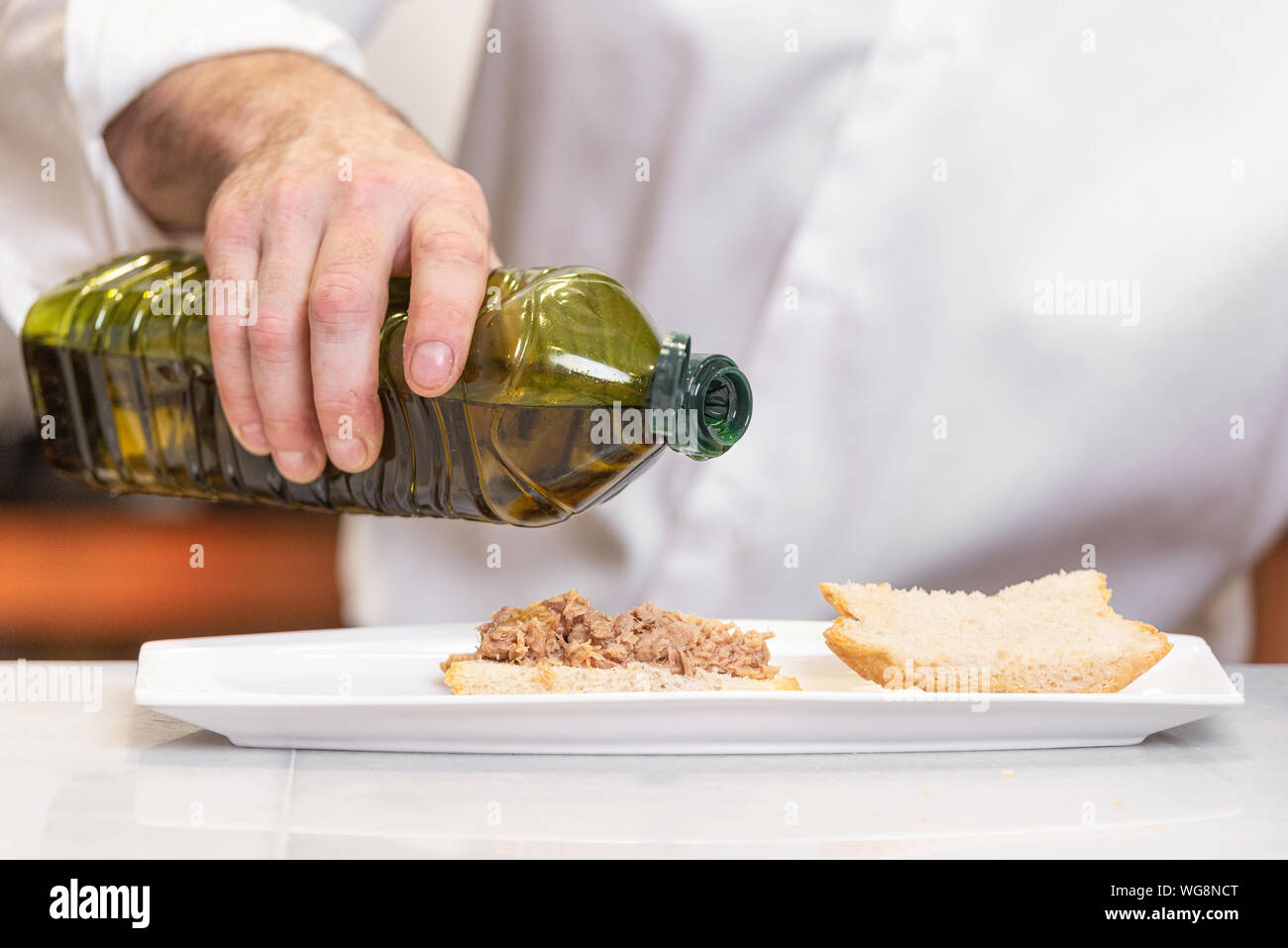 Chef pouring olive oil over delicious meal Stock Photo Alamy