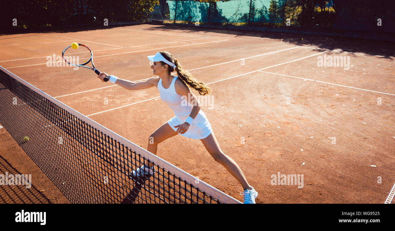 Woman hitting the tennis ball on the court Stock Photo