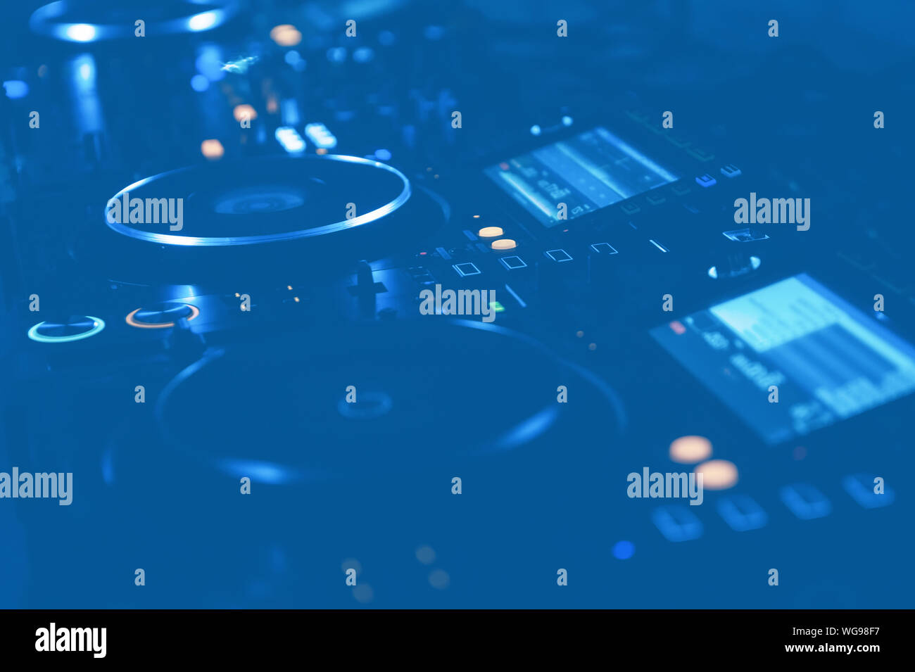 Professional dj turntables setup on stage in blue lights.Hip hop disc jockey turn table system