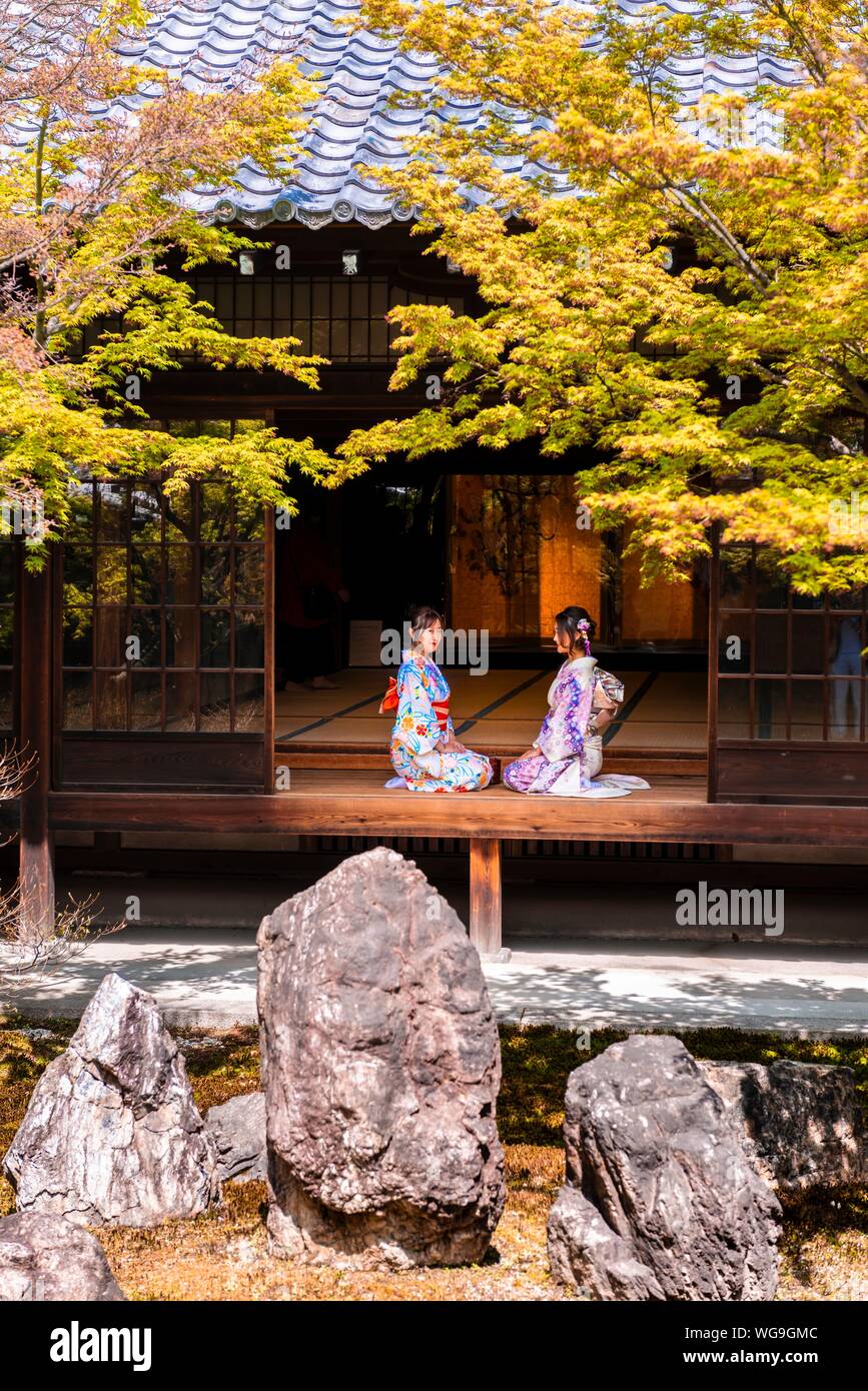 Two Japanese women dressed with kimono sitting in the courtyard of O-shoin, Kennin-ji Temple, Higashiyama, Kyoto, Japan Stock Photo