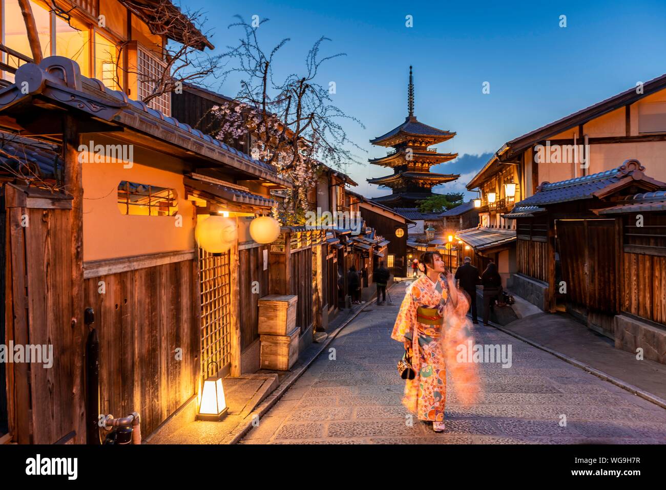 Woman in kimono in a lane, Yasaka dori historical alleyway in the old town with traditional Japanese houses, behind five-storey Yasaka pagoda of the Stock Photo