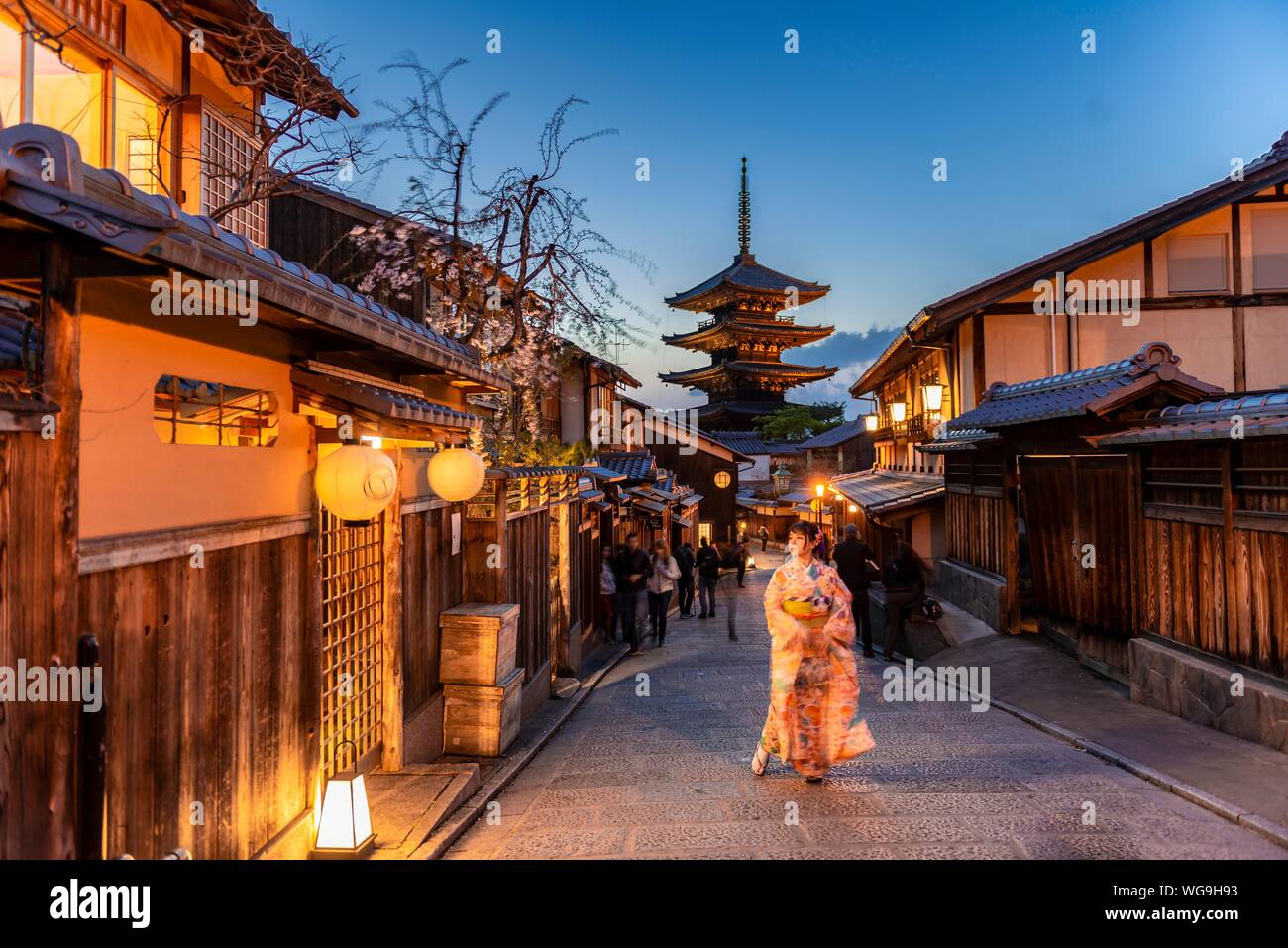 Woman in kimono in a lane, Yasaka dori historical alleyway in the old town with traditional Japanese houses, behind five-storey Yasaka pagoda of the Stock Photo