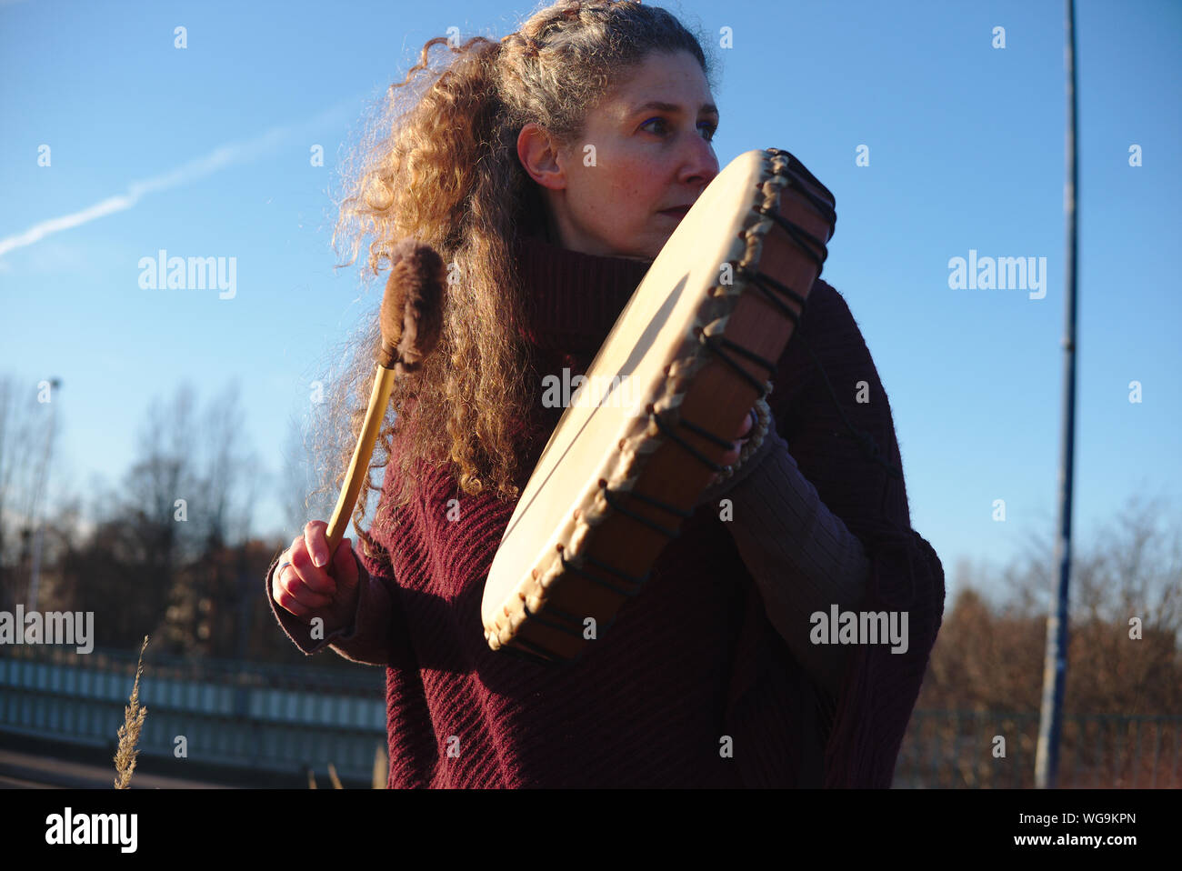 Woman Playing Musical Instrument While Standing Against Sky Stock Photo