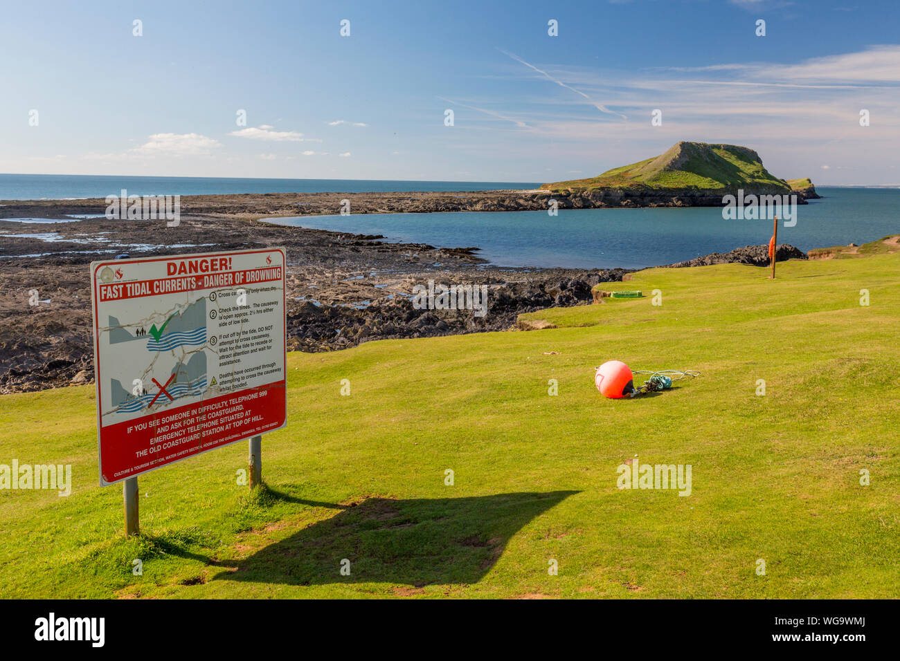 Warnig signs about the danger of crossing the causeway at Worms Head at low tide on the Gower peninsula, South Wales, UK Stock Photo