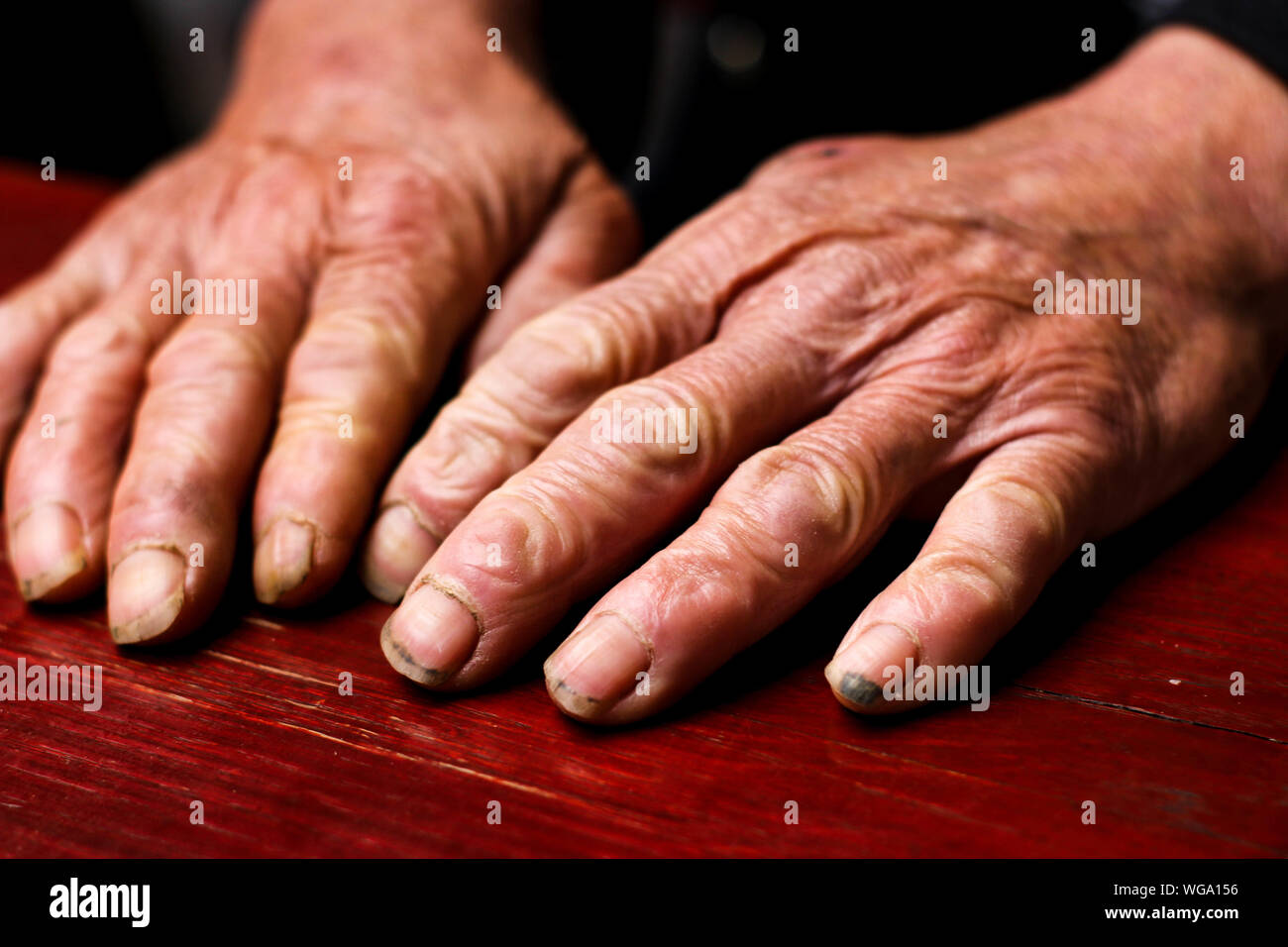 Cropped Hands Of Senior Adult On Table Stock Photo