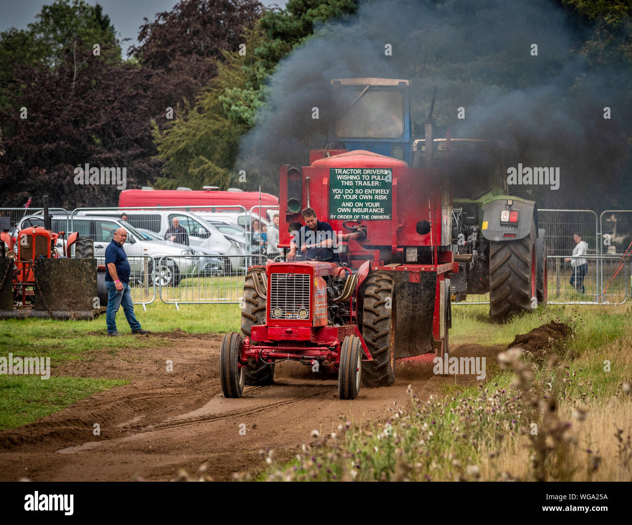 Tractor pulling challenge. Tractor dragging a metal sled along a track containing a box filled with weight. Stock Photo