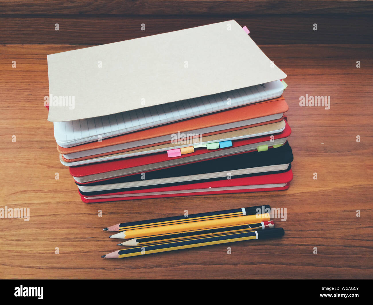 High Angle View Of Diaries With Pencils On Wooden Table Stock Photo