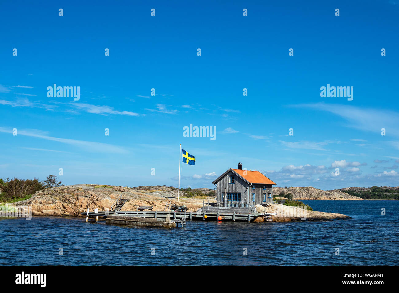 Cottage and flag on the island Valoen near the city Fjaellbacka in Sweden. Stock Photo