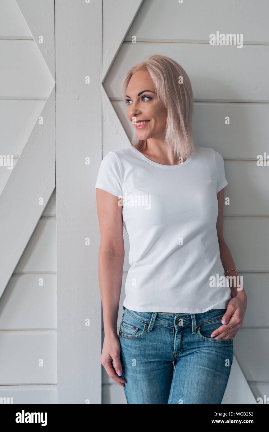 Portrait of a beautiful smiling blonde. Ready-made white t-shirt layout for design. Stock Photo