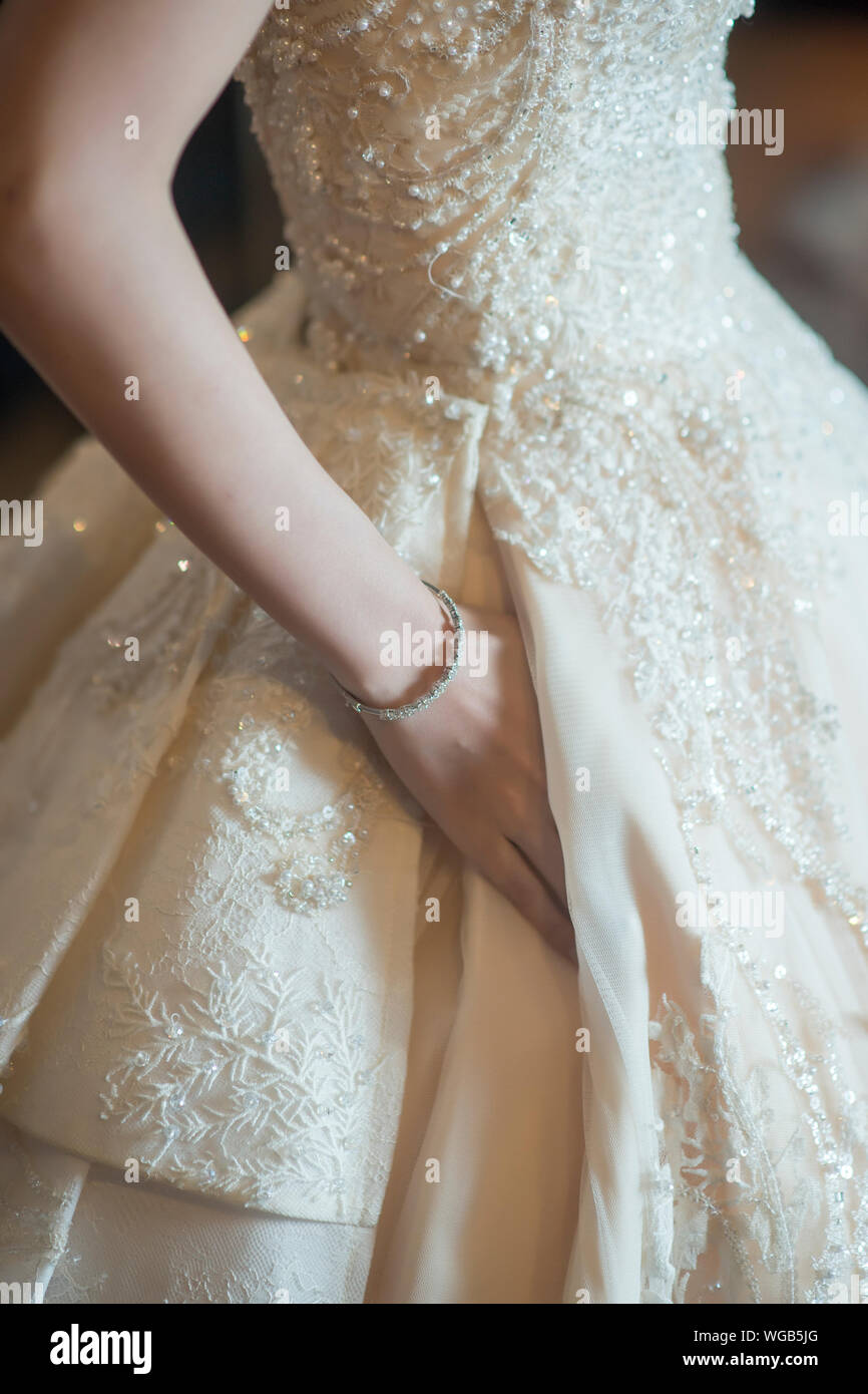 Midsection Of Bride Wearing White Wedding Dress Stock Photo