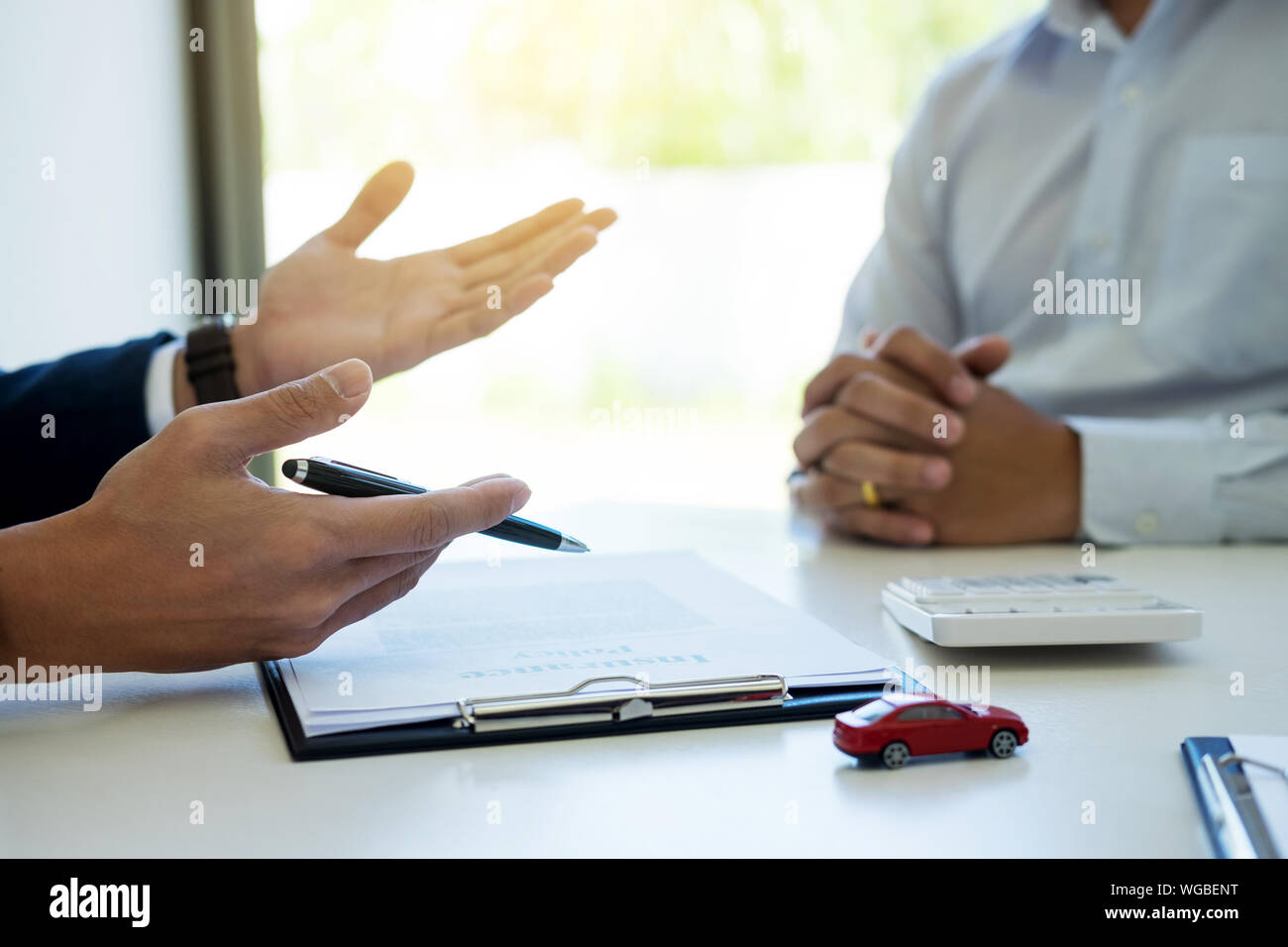 Cropped Image Of Car Salesperson Gesturing While Communicating With Customer At Desk Stock Photo