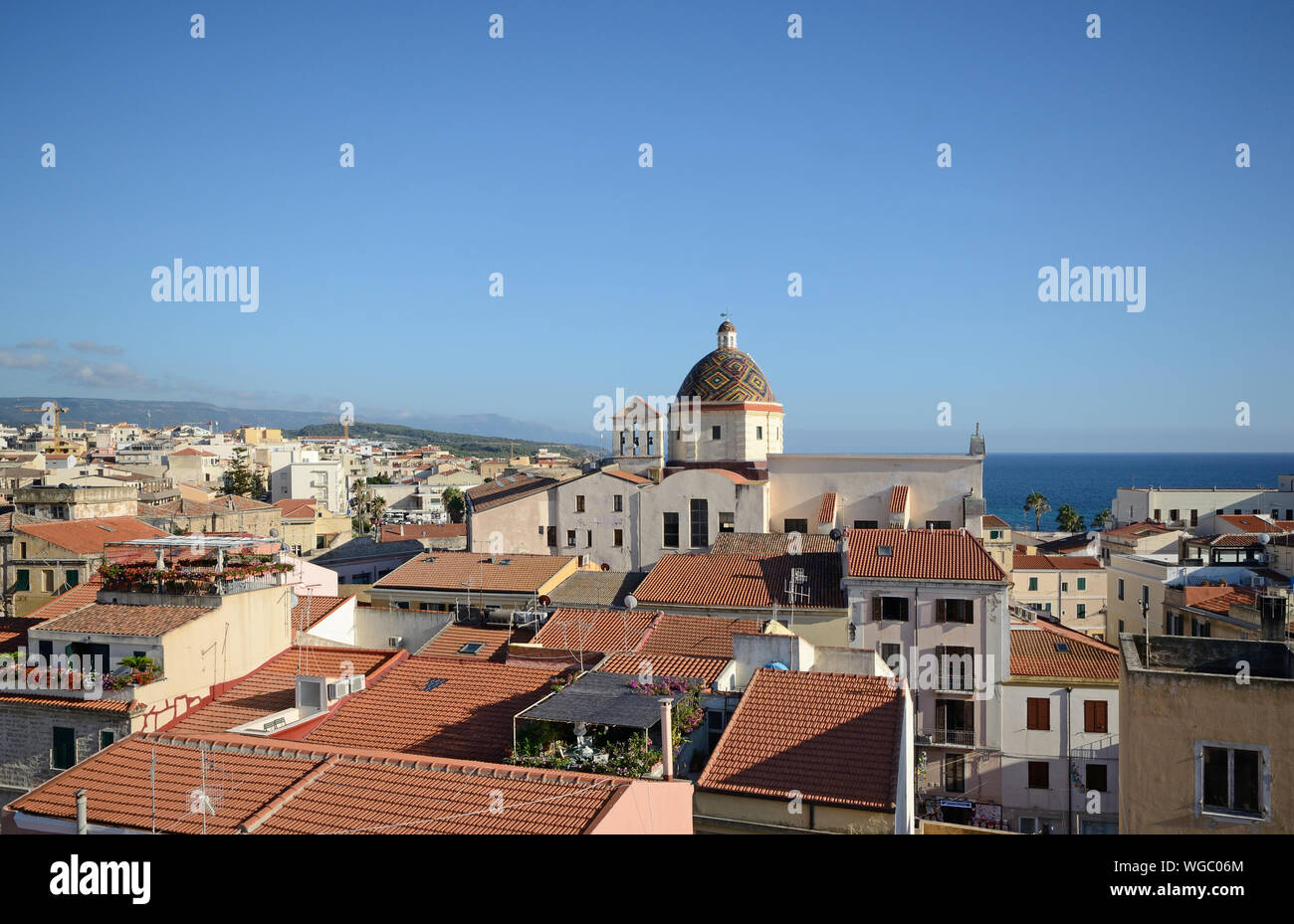 Aerial view of Alghero, city of Sardinia, with the majolica dome of the church of San Michele in evidence, and the sea in the background Stock Photo