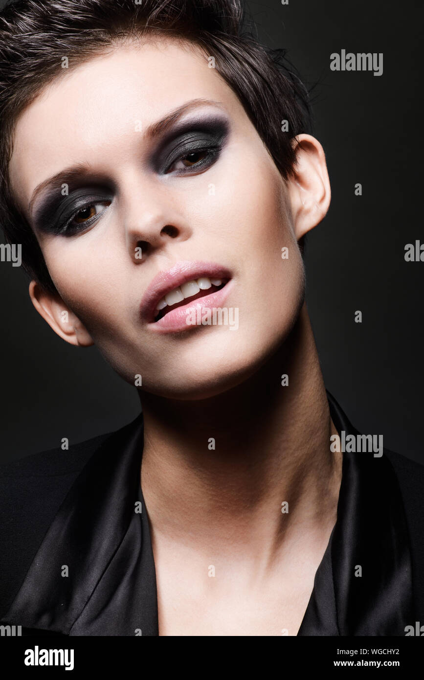 Fashion Head Shot Of Brunette Woman With Short Hair Cut On Black