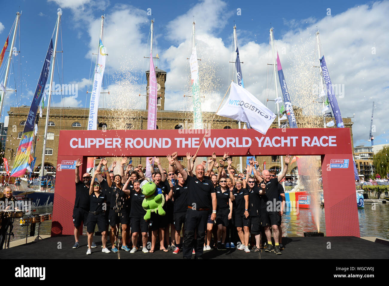 The WTC Logistics team, one of 11 taking part in the Clipper Round the World Race, waves to crowds at the Departure Ceremony at St Katharine Docks Marina by the river Thames in central London, before their departure down the river. Stock Photo