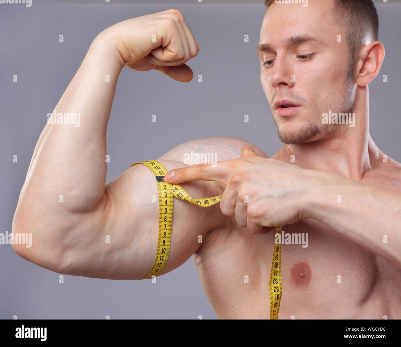 https://c8.alamy.com/comp/WGCYBC/image-of-muscular-man-measure-his-biceps-with-measuring-tape-in-centimeters-WGCYBC.jpg