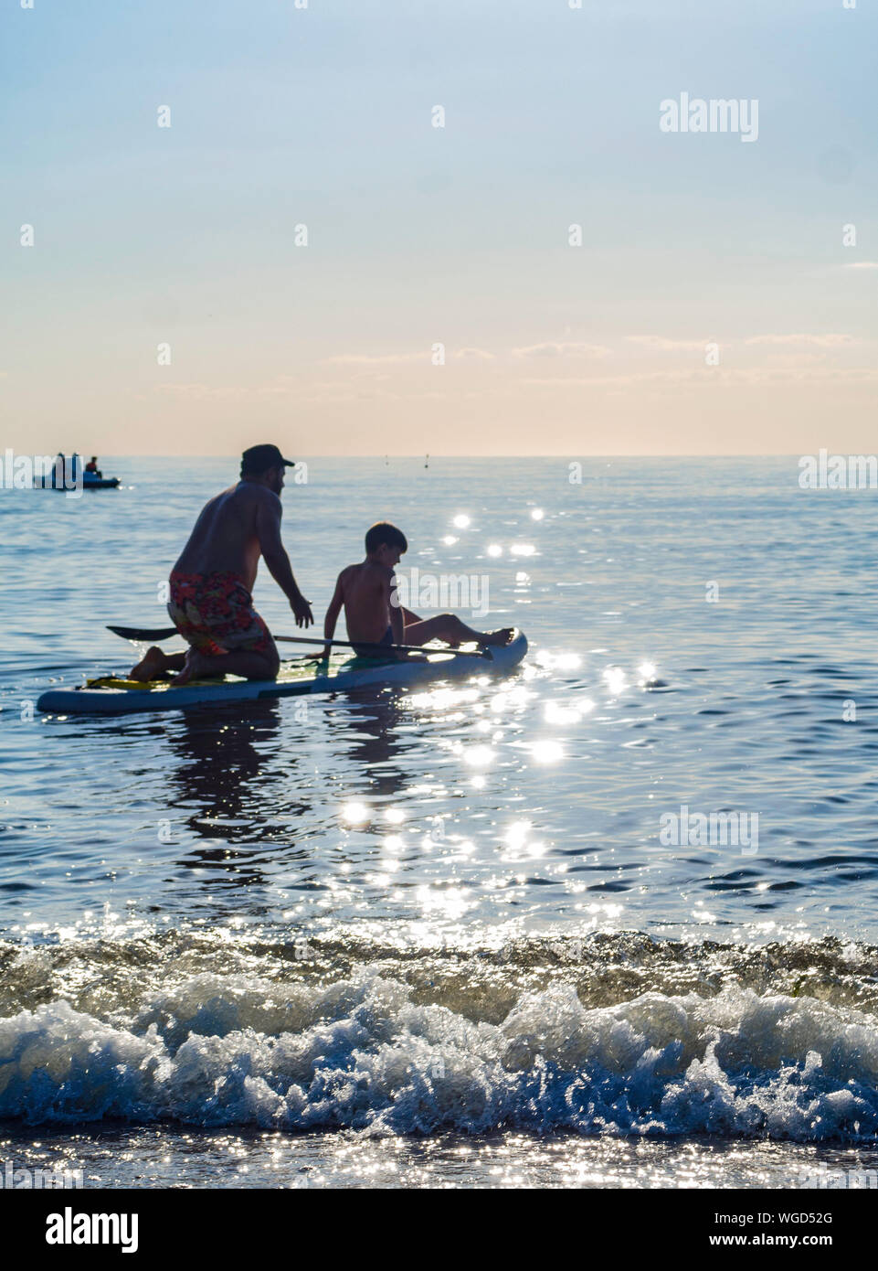 Sup surfing training, father and sun swim in the open sea on SAP